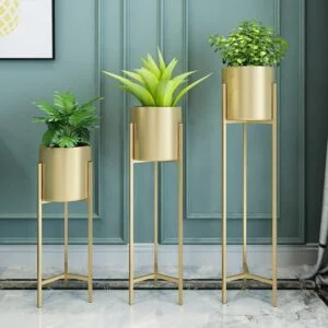 Modern gold metal planters with green plants in a stylish interior setting.
