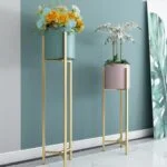 Modern gold metal planters with flowers in a stylish interior setting.