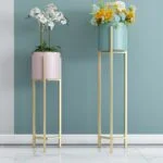 Modern gold metal planters with flowers, perfect for luxury home decor.