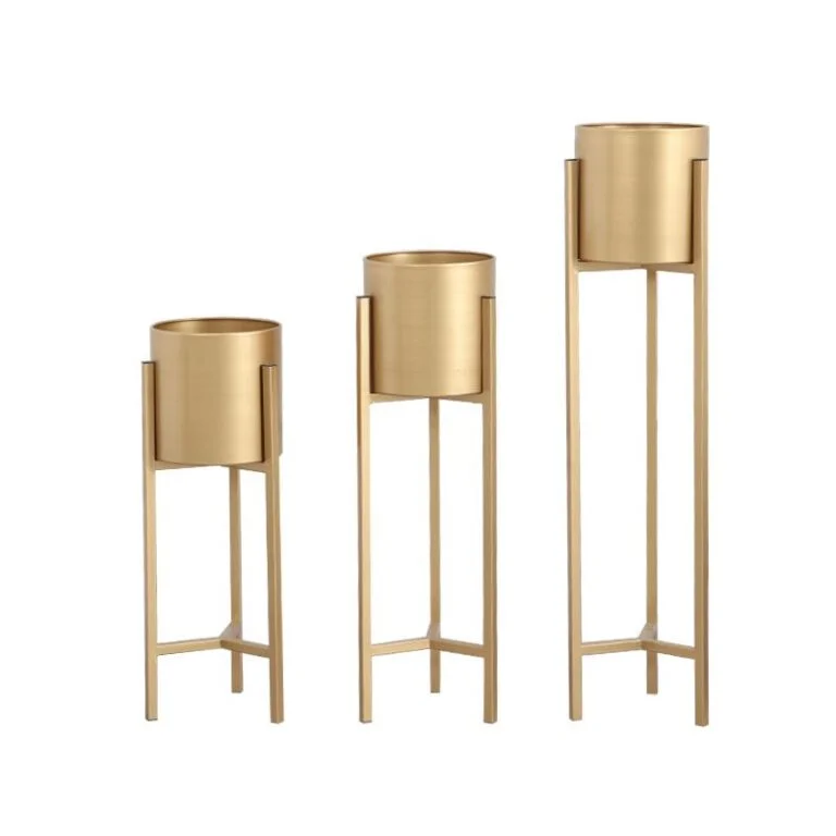 Set of three gold metal planters with stands for modern home decor.