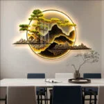 Illuminated modern wall art with mountain and tree design in a dining room setting.