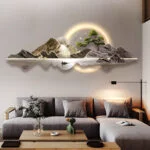 Modern illuminated wall art with mountain landscape above a sofa in a stylish living room.