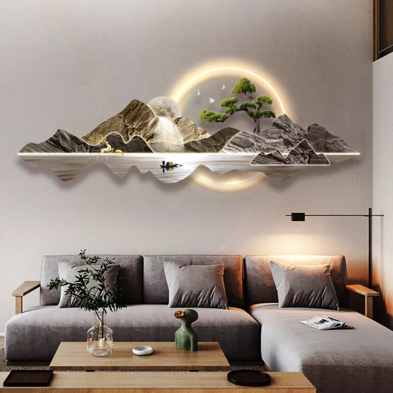 Modern illuminated wall art with mountain landscape above a sofa in a stylish living room.