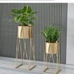 Modern gold metal planters with green plants on a sleek floor, enhancing luxury home decor.