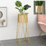 Modern gold indoor planter with geometric stand in a stylish living room setting.