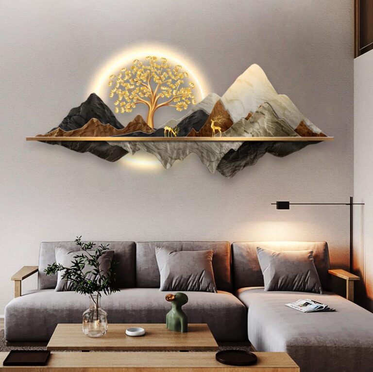 Modern illuminated wall art with mountain and tree design above a stylish living room sofa.