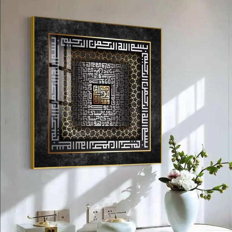 Modern Islamic wall art with Arabic calligraphy in a gold and black frame, displayed in a stylish interior.