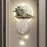 Modern illuminated wall art with circular design and nature elements in a hallway.