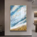 Modern abstract wall art with blue and gold tones in a gold frame, enhancing luxury home decor.