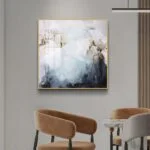 Modern abstract wall art with gold frame in a stylish living room setting.
