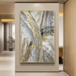 Modern abstract wall art with gold and gray tones in a luxury home setting.