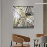 Modern abstract wall art with gold and gray tones in a luxury home setting.