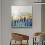 Modern luxury wall art with gold and blue abstract design in a living room setting.