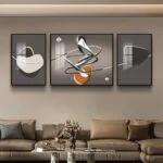 Modern abstract wall art in black frames above a beige sofa in a stylish living room.