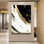 Modern abstract wall art with black, white, and gold swirls in a hallway setting.