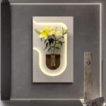 Modern illuminated wall art with flowers in a vase, enhancing luxury home decor.