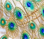 Colorful metal wall art with peacock feather design featuring blue and amber accents.