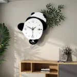 Modern panda-shaped wall clock in a stylish living room setting with plants and decor.