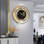 Modern luxury wall clock with gold accents in a stylish living room setting.