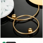 Modern decorative wall clock with gold metal rings and marble accents.