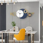 Modern luxury wall clock with geometric design in a stylish dining room setting.