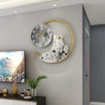 Modern wall clock with astronaut figurine and gold accents in a luxury living room setting.