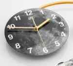 Modern decorative wall clock with moon design and gold accents.