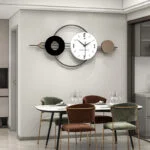 Modern decorative wall clock in dining room with elegant chairs and table setting.