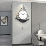 Modern wall clock with geometric design in a contemporary dining room setting.