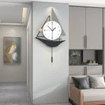 Modern decorative wall clock in a stylish living room with framed wall art and neutral decor.