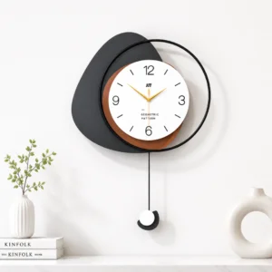 Modern decorative wall clock with geometric design and pendulum, styled with vases and books on a shelf.
