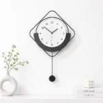 Modern black and white wall clock with minimalist design and decorative accents.