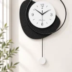 Modern black and white wall clock with abstract design in a stylish interior setting.