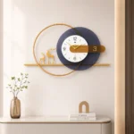 Modern luxury wall clock with gold accents and decorative deer figurines on a shelf.