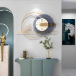Modern luxury wall clock with decorative accents and sculptures in a stylish home setting.