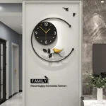 Modern decorative wall clock with bird and leaf design in a luxury home setting.