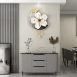 Modern decorative wall clock with floral design above a sleek console table in a stylish living room.