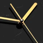 Modern luxury wall clock with gold hands on a black marble background.