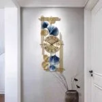 Modern decorative wall clock with gold and blue accents in a hallway.