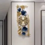 Modern luxury wall clock with gold and blue decorative accents in a hallway.