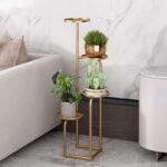Modern gold metal indoor planter with three levels holding various plants, placed beside a sofa.