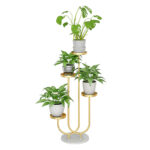 Modern gold metal plant stand with multiple levels and potted green plants.