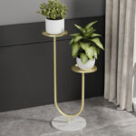 Modern gold metal planter with two plants on a marble base, ideal for luxury home decor.