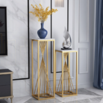 Modern home decor with gold stands, blue vase, and abstract sculpture.