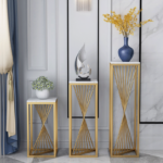 Modern luxury home decor with gold stands, vases, and sculptures in a stylish interior setting.