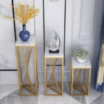 Modern luxury home decor with gold stands, blue vase, and decorative sculpture.