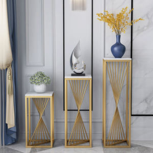Modern luxury home decor with gold stands, vases, and sculptures in a stylish interior setting.