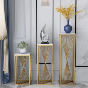 Modern luxury home decor with gold stands, vases, and sculptures in a stylish interior setting.