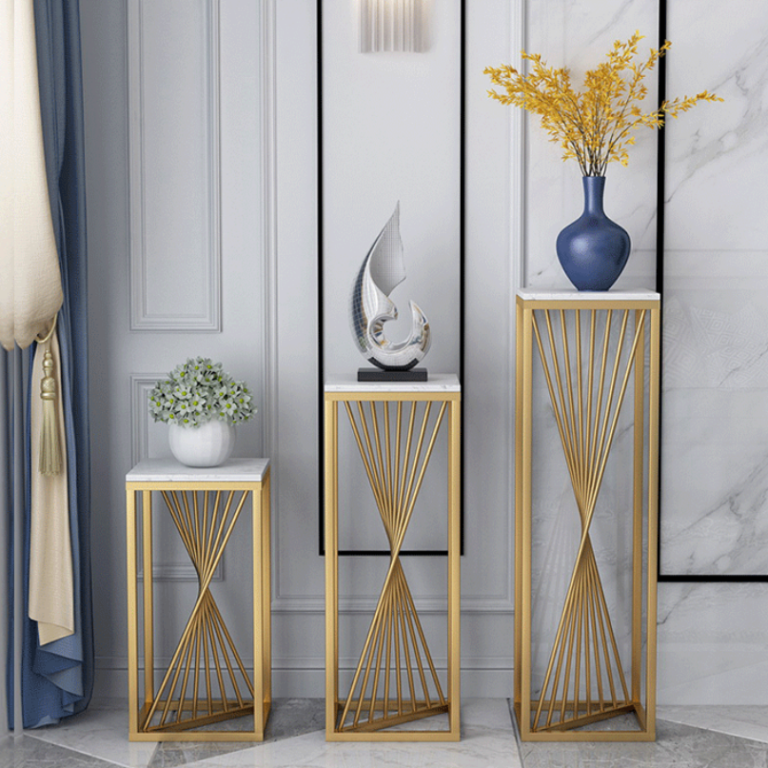 Modern luxury home decor with gold stands, vases, and sculptures in a stylish interior setting.