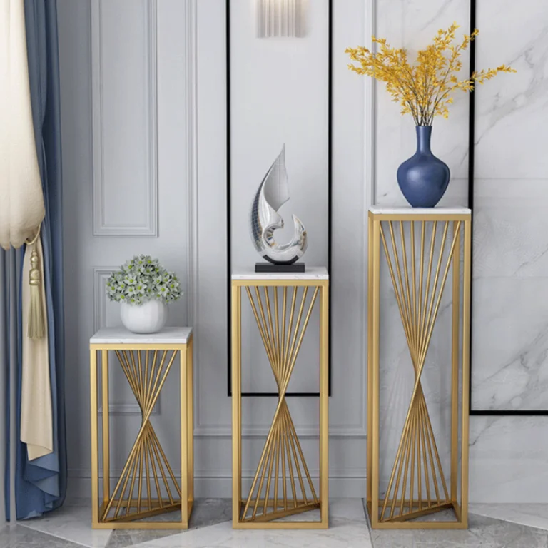 Modern luxury home decor with gold stands, vases, and sculptures in a stylish interior setting.